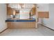 Cozy kitchen area with wood cabinets, tile counters, and an open layout to adjacent room at 2130 Frontier Ln, Franktown, CO 80116