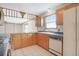 Functional kitchen featuring wood cabinetry, tile countertops and backsplash, plus modern appliances at 2130 Frontier Ln, Franktown, CO 80116
