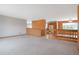 Open-concept living room with neutral walls, bright carpet, and a view of the kitchen at 2130 Frontier Ln, Franktown, CO 80116