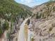 Stunning aerial view of a mountain home nestled among trees, with a road and river winding through the valley at 4364 Colorado 103, Idaho Springs, CO 80452
