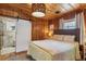 Cozy bedroom with wood paneling and modern sliding door to the bathroom at 4364 Colorado 103, Idaho Springs, CO 80452