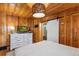 Spacious bedroom featuring wood paneling and an adjacent bathroom with a sliding door at 4364 Colorado 103, Idaho Springs, CO 80452