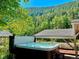 Relaxing hot tub on a deck overlooking a forest, with mountain views and a covered patio at 4364 Colorado 103, Idaho Springs, CO 80452