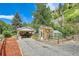 Charming home with covered parking and a greenhouse, set against a backdrop of lush greenery and mountain views at 4364 Colorado 103, Idaho Springs, CO 80452