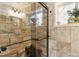 Walk-in shower features stone walls and glass doors next to tiled walls and a window at 4364 Colorado 103, Idaho Springs, CO 80452