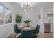 Sunlit dining area features a modern chandelier, table with seating and adjacent access to kitchen at 1060 S Parker Rd # 36, Denver, CO 80231