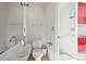 Clean, modern bathroom with simple fixtures and bright red kitchenette at 2565 Champa St, Denver, CO 80205