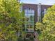 Modern brick home with a glass facade and multiple levels of outdoor space, surrounded by mature trees at 2565 Champa St, Denver, CO 80205