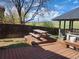 Outdoor dining area on wooden deck with gazebo, picnic table, and backyard views at 812 S Ouray St, Aurora, CO 80017