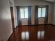 Inviting living room featuring gleaming hardwood floors and two windows covered by gray curtains at 812 S Ouray St, Aurora, CO 80017