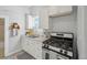 Small kitchen with white cabinets, gas range, and double sink at 3500 N Marion St, Denver, CO 80205