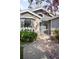 Close-up view of a charming single-story home entrance with landscaped walkway and blooming tree at 8080 E Dartmouth Ave # 26, Denver, CO 80231