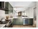 Bright kitchen with modern green cabinets, stainless steel appliances, quartz counters, and open living space at 8080 E Dartmouth Ave # 26, Denver, CO 80231