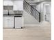 Basement wet bar features a mini fridge, granite countertop, white cabinets, and modern black fixtures at 8080 E Dartmouth Ave # 26, Denver, CO 80231
