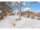 Backyard view of home with shed and snow-covered lawn at 12008 W Mexico Pl, Lakewood, CO 80228