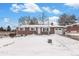 Ranch style brick home with a snow covered yard at 12008 W Mexico Pl, Lakewood, CO 80228