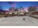 Brick ranch house with attached garage, snow-covered yard, and twilight sky at 12008 W Mexico Pl, Lakewood, CO 80228