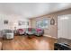 Living room featuring hardwood floors, gray sectional, and vintage decor at 12008 W Mexico Pl, Lakewood, CO 80228