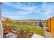 Landscaped backyard features a fire pit, small tree, mulch, and wooden fence at 174 Rockingham Cir, Castle Pines, CO 80108