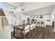 Open-concept dining area with hardwood floors, a modern table, and an adjacent white kitchen at 174 Rockingham Cir, Castle Pines, CO 80108