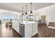 Open-concept kitchen with a large island, stainless steel appliances, and views of the dining and living areas at 174 Rockingham Cir, Castle Pines, CO 80108