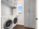 Laundry room featuring gray cabinets, a window for natural light, and modern washer and dryer at 174 Rockingham Cir, Castle Pines, CO 80108