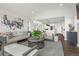 Open-concept living area with modern decor, hardwood floors, and an adjacent kitchen and dining space at 174 Rockingham Cir, Castle Pines, CO 80108