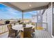 This covered patio area features scenic views, a table with seating, and flower boxes along the railing at 174 Rockingham Cir, Castle Pines, CO 80108