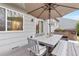 Outdoor deck with a dining table, umbrella, and hot tub, perfect for outdoor entertaining and relaxation at 5426 Bobcat St, Frederick, CO 80504