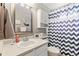 Bright bathroom featuring a vanity with ample counter space, and a shower-tub combo with a decorative curtain at 5426 Bobcat St, Frederick, CO 80504
