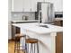 Modern kitchen island with white countertop and stools at 1218 Perry St, Denver, CO 80204