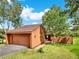 Warm exterior view of house with a brown roof, garage, and lush green lawn with a driveway at 953 Gilia Dr, Golden, CO 80401