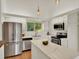 Bright kitchen with white cabinets, stainless steel appliances, and large island with marble countertop at 953 Gilia Dr, Golden, CO 80401