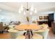 Open-concept dining room with a glass table, stylish seating, and views to the kitchen and living spaces at 6325 W Portland Pl, Littleton, CO 80128