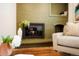 A close up of a traditional style brick fireplace with a burning fire and seating nearby at 6325 W Portland Pl, Littleton, CO 80128