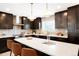 Stylish kitchen with dark cabinetry, a large island with seating, and stainless steel appliances at 6325 W Portland Pl, Littleton, CO 80128