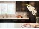 Modern kitchen featuring dark wood cabinets, quartz countertops, a tile backsplash, and a bright window at 6325 W Portland Pl, Littleton, CO 80128
