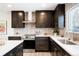 Well-designed kitchen with dark cabinets, stainless steel appliances, and bright quartz countertops at 6325 W Portland Pl, Littleton, CO 80128