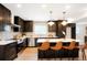 Modern kitchen with dark cabinets, stainless steel appliances, quartz countertops, and pendant lighting at 6325 W Portland Pl, Littleton, CO 80128