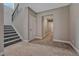 A carpeted hallway and staircase with neutral walls and white trim lead to upper levels, offering a bright and open feel at 4213 Hickory Oaks St, Castle Rock, CO 80104