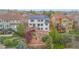Aerial view of a two-story home with solar panels, multi-level patio, and mature landscaping at 6614 W Gould Dr, Littleton, CO 80123