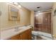 Bathroom features a single sink vanity, framed mirror, and a glass enclosed shower with tile surround at 6614 W Gould Dr, Littleton, CO 80123