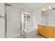Bathroom featuring a large soaking tub, glass-enclosed shower, and vanity with plenty of counter space at 6614 W Gould Dr, Littleton, CO 80123