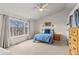 Comfortable bedroom featuring large windows with natural light, a ceiling fan, and neutral carpet at 6614 W Gould Dr, Littleton, CO 80123