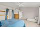Bright bedroom with a ceiling fan, blue accents, and a comfortable seating area at 6614 W Gould Dr, Littleton, CO 80123