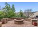 Stone patio with brick fire pit, stone seating, manicured landscaping, and neighborhood views at 6614 W Gould Dr, Littleton, CO 80123