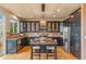 This kitchen features dark cabinets, stainless appliances, tile backsplash, and an island with bar stool seating at 6614 W Gould Dr, Littleton, CO 80123