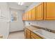 Functional laundry room with a sink, countertop, and ample storage cabinets above at 6614 W Gould Dr, Littleton, CO 80123