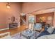 Open-concept living space with hardwood floors, high ceilings, a cozy seating area, and a staircase in the background at 6614 W Gould Dr, Littleton, CO 80123