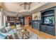 Open-concept living room with hardwood floors, a fireplace, and a view into the modern black kitchen at 6614 W Gould Dr, Littleton, CO 80123